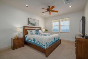 een slaapkamer met een bed en een plafondventilator bij Oceanfront Condo Halii Kai 14D in Waikoloa +26 foto's