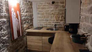 una cucina con un lavello e un muro di mattoni di Luxury suite lilas 5 a Digione Altre 5 foto