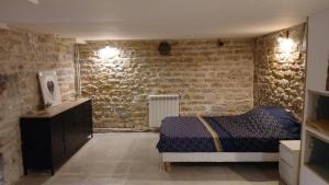 una camera da letto con un letto e un muro di mattoni di Luxury suite lilas 5 a Digione