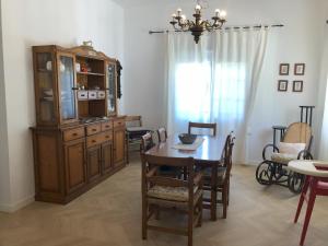 ein Esszimmer mit einem Tisch und einem Porzellankrank in der Unterkunft Casa San Rafael, magnífico chalet con gran jardín in Navajas