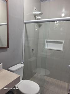 een badkamer met toilet en glazen douche bij Pousada jks in Porto Seguro +35 foto's