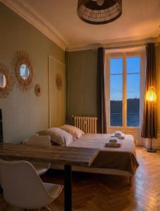 een slaapkamer met een groot bed en een groot raam bij Bois Émeraude in Aix-les-Bains