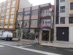 a building on the corner of a city street at Piso de Perlío, ideal para gente amante de la pla in Fene