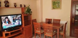 a dining room with a table and a television at Piso de Perlío, ideal para gente amante de la pla in Fene +10 photos