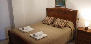 a bedroom with a bed with two towels on it at Piso de Perlío, ideal para gente amante de la pla in Fene