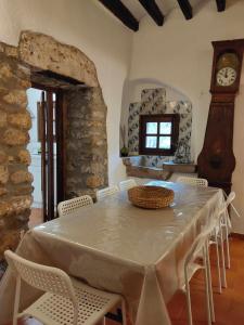 ein Esszimmer mit einem Tisch und einer Großvater-Uhr in der Unterkunft Can Canals Rectoria de Dosquers in Maia de Montcal