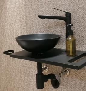 a black bowl sink and a bottle on a shelf at Auditorio Rooms Boutique Oviedo in Oviedo