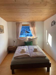 a bedroom with a large bed with a window at Krumm und Schief Appartments in Brunau