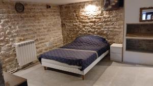 een slaapkamer met een bed in een bakstenen muur bij Luxury Suite Lilas in Dijon