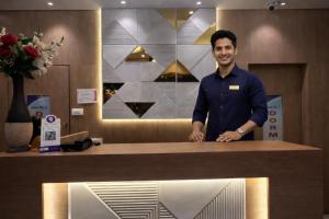 een man achter een toonbank in een winkel bij Relax Kurla Dormitory in Mumbai