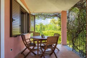 eine Terrasse mit Tisch und Stühlen auf einem Balkon in der Unterkunft Casa Vacanze l'Olivastro in Àrbatax