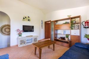 ein Wohnzimmer mit Sofa und Tisch in der Unterkunft Casa Vacanze l'Olivastro in Àrbatax