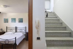 ein Schlafzimmer mit einem Bett und einem Telefon neben einer Treppe in der Unterkunft Casa Vacanze l'Olivastro in Àrbatax