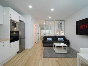 een woonkamer met een zwarte bank en een keuken bij Moguel Canarian Holiday 1º in Arguineguín