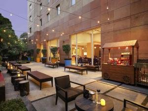 a patio with tables and chairs and a building at ibis Pune Viman Nagar - An Accor Brand in Pune