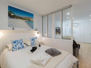 een slaapkamer met een wit bed met blauwe en witte kussens bij Moguel Canarian Holiday 1º in Arguineguín +40 foto's