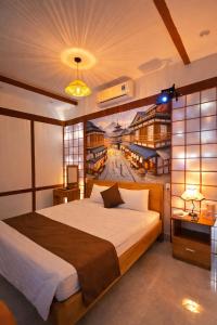 a bedroom with a large bed with a painting on the wall at Dopamine Hotel in Vung Tau