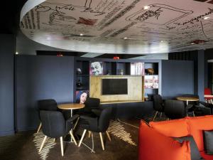 een kamer met een tafel, stoelen en een tv bij ibis Swansea in Swansea