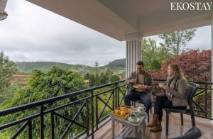 a man and woman sitting on a porch with food at EKOSTAY - Villa Eve in Ooty +23 photos