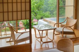 a room with chairs and a table and a pool at 御宿竹林亭 in Takeo