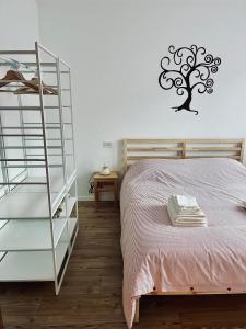 - une chambre avec un lit et un arbre sur le mur dans l'établissement Al Monte Zelo, à Rome