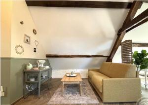 ein Wohnzimmer mit Sofa und Tisch in der Unterkunft Le petit jardin du Coudray in Étréchy