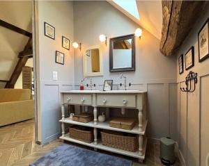 ein Badezimmer mit Waschbecken und Spiegel in der Unterkunft Le petit jardin du Coudray in Étréchy