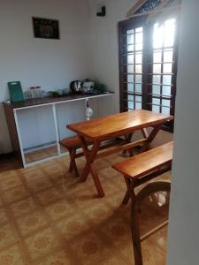 une table et des bancs dans une pièce avec une cuisine dans l'établissement Grand Ceylon Hotel & Apartment Hikkaduwa, à Hikkaduwa 24 autres photos