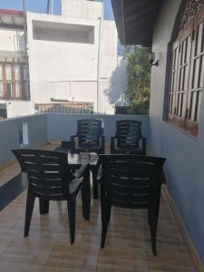 une table noire et des chaises sur une terrasse dans l'établissement Grand Ceylon Hotel & Apartment Hikkaduwa, à Hikkaduwa