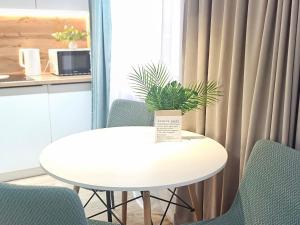 a white table with chairs and a potted plant on it at Глинки 1комн in Semey +2 photos