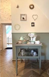 Ein Tisch in einem Zimmer mit einigen Gegenständen an der Wand in der Unterkunft Le petit jardin du Coudray in Étréchy