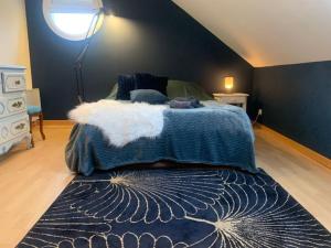 a bedroom with a bed with a blue blanket and a window at Prés de l'aeroport in Ossun