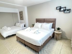 een slaapkamer met twee bedden met witte lakens bij Ramon Palms in Mitzpe Ramon