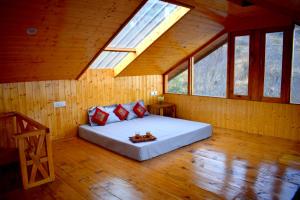 a bedroom with a bed in a room with windows at Top Mountain Mist Near Jibhi in Banjār +10 photos
