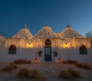 a white building with christmas lights on it at Trulli sul Mare Forcatella in Savelletri di Fasano