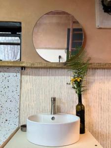 a bathroom sink with a vase with a flower in it at Samstay Đà Lạt in Ấp Ða Lợi +35 photos