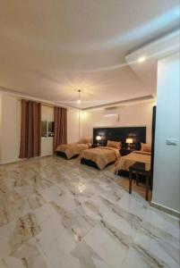 a large bedroom with two beds and a marble floor at I cloud Petra hostel in Wadi Musa +10 photos