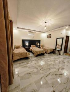 a bedroom with two beds and a stone floor at I cloud Petra hostel in Wadi Musa