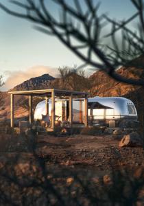 Ein Zelt und ein Wohnwagen, die in der Wüste geparkt sind in der Unterkunft Nomad By Sharjah Collection in Kalbā