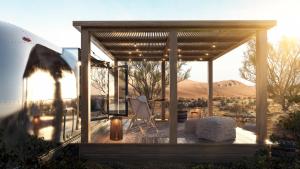 ein Pavillon mit einem Tisch und einem Stuhl auf einem Deck in der Unterkunft Nomad By Sharjah Collection in Kalbā