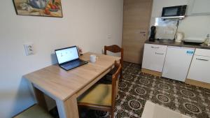 a laptop computer sitting on a wooden table in a kitchen at Family apartments "Hamster" up to 7 persons in Zgornja Polskava