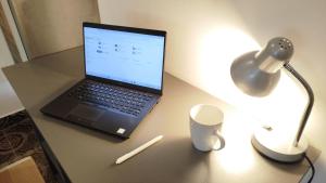a laptop computer sitting on a desk with a lamp at Family apartments "Hamster" up to 7 persons in Zgornja Polskava