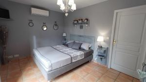 una camera da letto con un letto e un lampadario di La Villa d'Olivène a Cuers Altre 21 foto