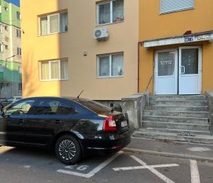 ein schwarzes Auto, das vor einem Gebäude geparkt ist in der Unterkunft Big Apartment in Turda