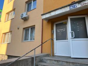 a building with a door and stairs in front of it at Big Apartment in Turda