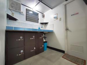 une cuisine avec des placards bruns et un comptoir bleu dans l'établissement Ezekiel Transient House, à Coron