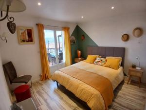een slaapkamer met een bed, een stoel en een raam bij Hauts de st pierre belle terrasse in Fayence