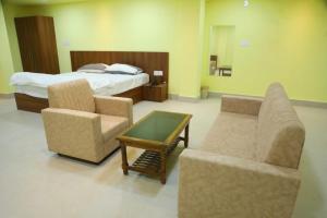 a hotel room with a bed and a couch and chairs at Manab Palace in Kendrāparha