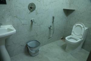 a bathroom with a toilet and a sink at Manab Palace in Kendrāparha