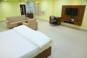 a hotel room with a bed and a tv at Manab Palace in Kendrāparha +14 photos